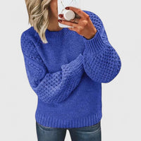 Pull ample en maille bleue, encolure ronde, manches longues, motifs en relief.