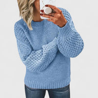 Pull ample en maille bleu clair, encolure ronde, manches longues, motifs en relief.