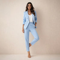 Ensemble veste à revers et pantalon tailleur bleu clair, boutons dorés et manches longues.