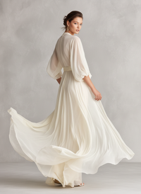 Robe longue ivoire transparente, manches bouffantes et jupe vaporeuse évasée.