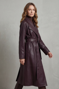 Trench en cuir prune ceinturé, porté de profil, fermeture croisée et col châle