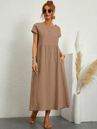 Robe midi fluide beige, encolure ronde, manches courtes, plis sous la poitrine.