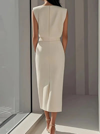 Robe midi crème au dos, taille marquée et fente latérale.