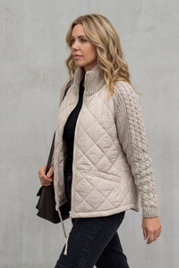Doudoune matelassée beige à empiècements maille vue de côté, fermeture zippée