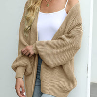 Cardigan Jeannine beige en maille texturée, col ouvert et manches lanterne amples.