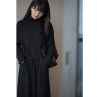 Robe longue en maille noire à col roulé, poches plaquées et ceinture nouée