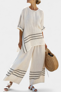 Haut asymétrique rayé blanc, encolure ronde, manches courtes, bandes bleu foncé.