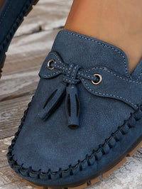 Mocassins orthopédiques en suède bleu, gros plan du laçage à glands.