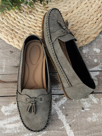 Mocassins orthopédiques en suède gris, semelle texturée et laçage à glands.