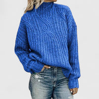 Pull torsadé bleu à col montant, manches longues et poignets côtelés.