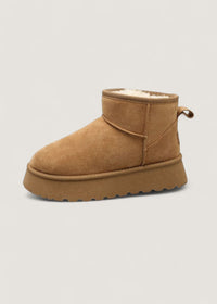 Botte d’hiver beige en suédine, col fourré et petit lacet latéral.