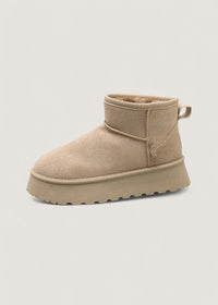 Botte d’hiver beige, col haut fourré et patte latérale, semelle épaisse.