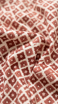 Zoom sur tissu rouge et blanc à motifs géométriques