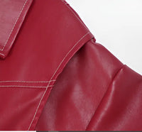 Gros plan sur veste en cuir rouge : coutures visibles et texture mate grainée.