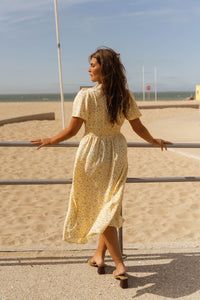 Robe midi fleurie jaune, manches courtes évasées, encolure en V, taille froncée