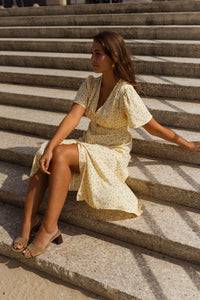 Robe midi fleurie jaune, manches courtes évasées, encolure en V, jupe à volants