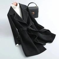 Manteau noir mi-long ceinturé, col à revers contrasté et boutonnage visible