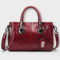 Sac polochon en cuir rouge, poignées tressées, poches zippées et bandoulière