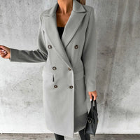 Manteau long en laine gris clair, col tailleur, boutons, poches plaquées.