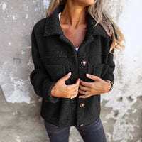 Veste courte en tissu bouclé noir, col châle, fermeture boutonnée, poches plaquées.