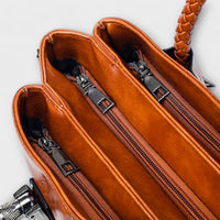 Intérieur de sac polochon en cuir cognac, doublure ambrée et compartiments zippés