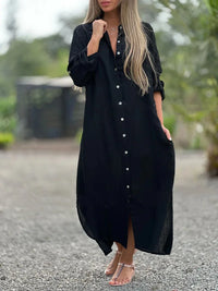 Robe-chemise noire fluide, manches longues retroussables, boutons décoratifs.