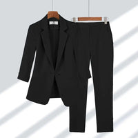 Ensemble blazer et pantalon noir, col à revers, boutonnage central, coupe tailleur.