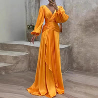 Robe longue fluide jaune, décolleté en V, manches bouffantes, drapé sur la jupe.