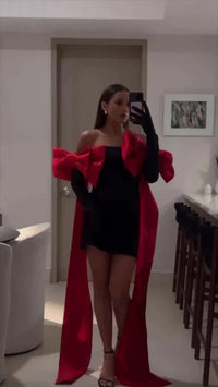 Robe noire courte avec nœuds rouges et longs pans fluides, vue miroir en intérieur
