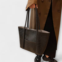 Sac à bandoulière vintage en cuir texturé brun foncé, poignées doubles et surpiqûres.