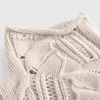 Détail du pull beige clair à torsades, col montant et maille texturée