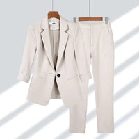 Ensemble blazer et pantalon beige clair, col à revers, boutonnage central, coupe tailleur.