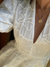 Robe bouffante blanche brodée près du buste, motif floral en relief