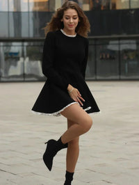 Robe noire Billie™ manches longues évasées, ourlet en dentelle blanche, vue de face en marche
