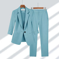 Ensemble blazer et pantalon turquoise, col à revers, boutonnage central, coupe tailleur.