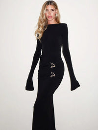 Robe longue noire unie à manches longues évasées, encolure ronde, appliqués brodés dorés.