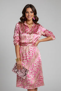 Robe élégante rose fuchsia à motifs, col boutonné, manches longues, jupe mi-longue évasée.