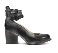 Bottines noires à talon moyen, brides à boucles, zip latéral et finition cuir lisse.