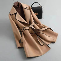 Manteau beige mi-long ceinturé, revers contrastés et patte de fermeture visible