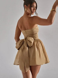 Robe bustier scintillante couleur champagne courte, nœud au dos et jupe évasée