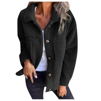 Veste courte en tissu bouclé noir, col châle, fermeture boutonnée, poches plaquées.