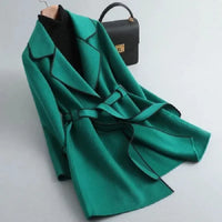 Manteau vert émeraude mi-long ceinturé, col à revers contrasté et lien à nouer