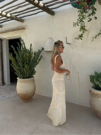 Robe longue beige en maille ajourée, coupe près du corps et motifs losanges.