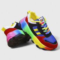 Chaussures orthopédiques multicolores, bout arrondi, semelle épaisse et lacets visibles.