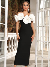 Robe fleurie noire midi, décolleté dégagé, manches bouffantes en fleurs blanches.