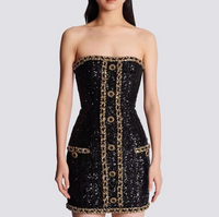 Robe bustier noire à sequins, bande dorée boutonnée au centre, coupe courte