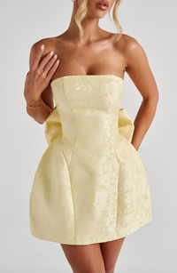 Robe courte jaune à corsage texturé et nœud volumineux à la taille