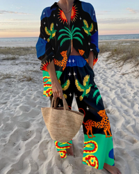 Ensemble deux pièces bleu nuit à motif animaux et palmiers, haut col V, pantalon ample.