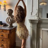 Robe mini irisée dorée à fines bretelles, franges métalliques, dos échancré