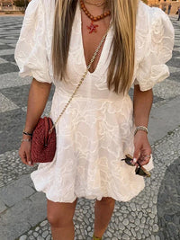 Robe bouffante blanche brodée, col en V et empiècement au niveau de la poitrine